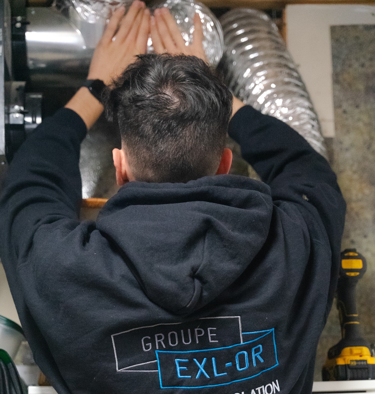 Technicien Groupe Exl-Or installant un échangeur d'air dans une maison à Québec